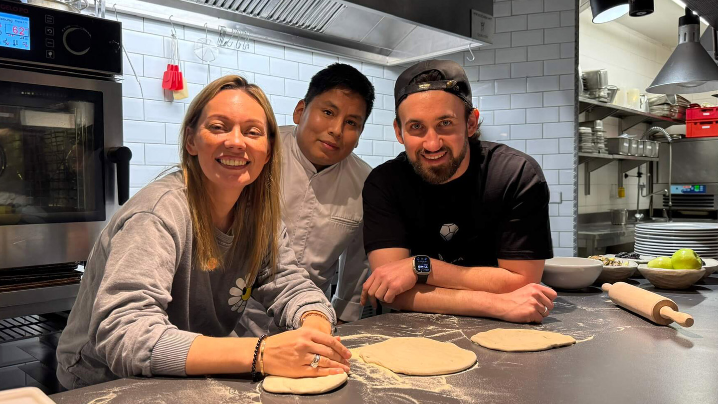Gabriel Khodzitski, CEO of PREA, Maria Köster, founder of Nano's Kids Club Berlin, and top chef Matias Diaz Silva prepare dough for pizza with refugee children at the charity cooking event at Restaurant 136 in Berlin-Mitte.